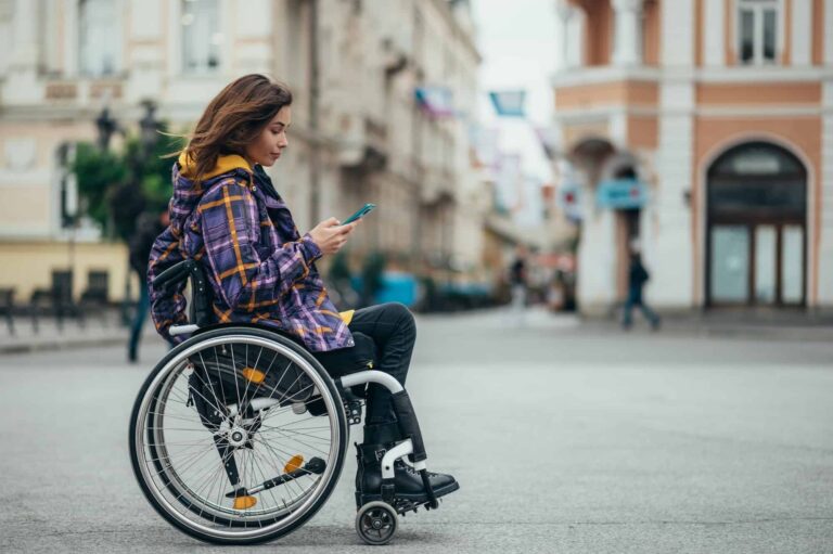 woman-with-disability-using-a-smartphone-while-out-in-the-city-768x511
